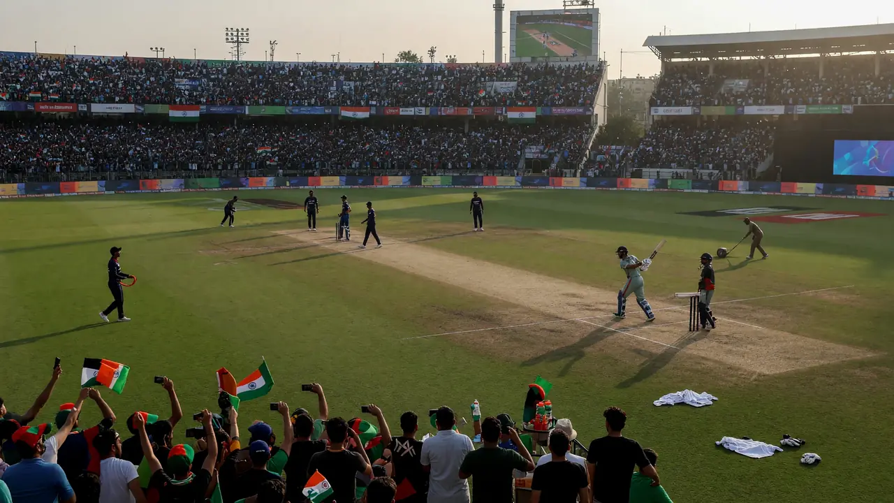 Wide afternoon view of a mountain-backed cricket stadium prepared for an ODI